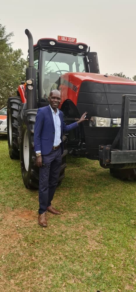 Rama Omonya standing beside a tractor at an agricultural exhibition